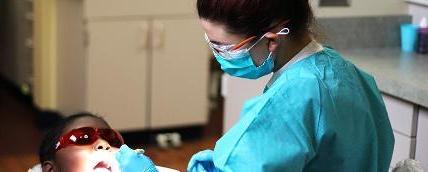 牙科学生用小手电筒检查儿童病人的口腔